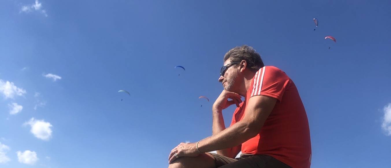 Rainer Weihe Inhaber | Geschäftsführung unter blauem Himmel umgeben von Paraglidern